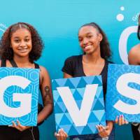 students posing in front of CAB backdrop holding GVSU letters and GV sign at Laker Kickoff photo booth